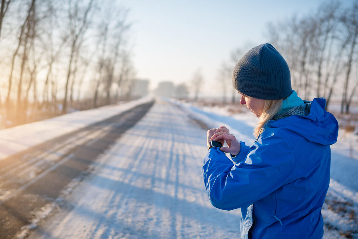 woman checking watch in winter.