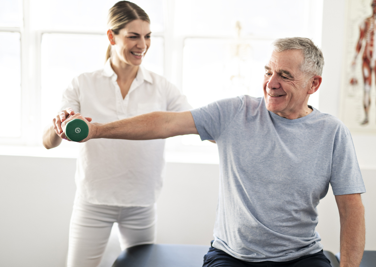 Physical therapy patient sitting on table lifting hand weight