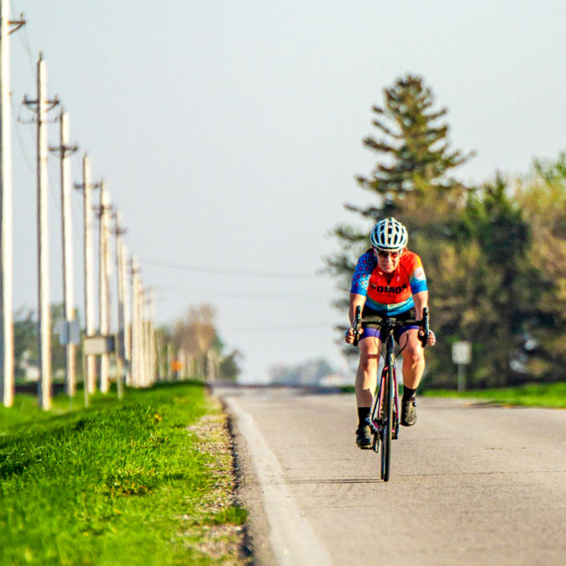 DMOS Racing Team bike rider cycling down a rode in Iowa
